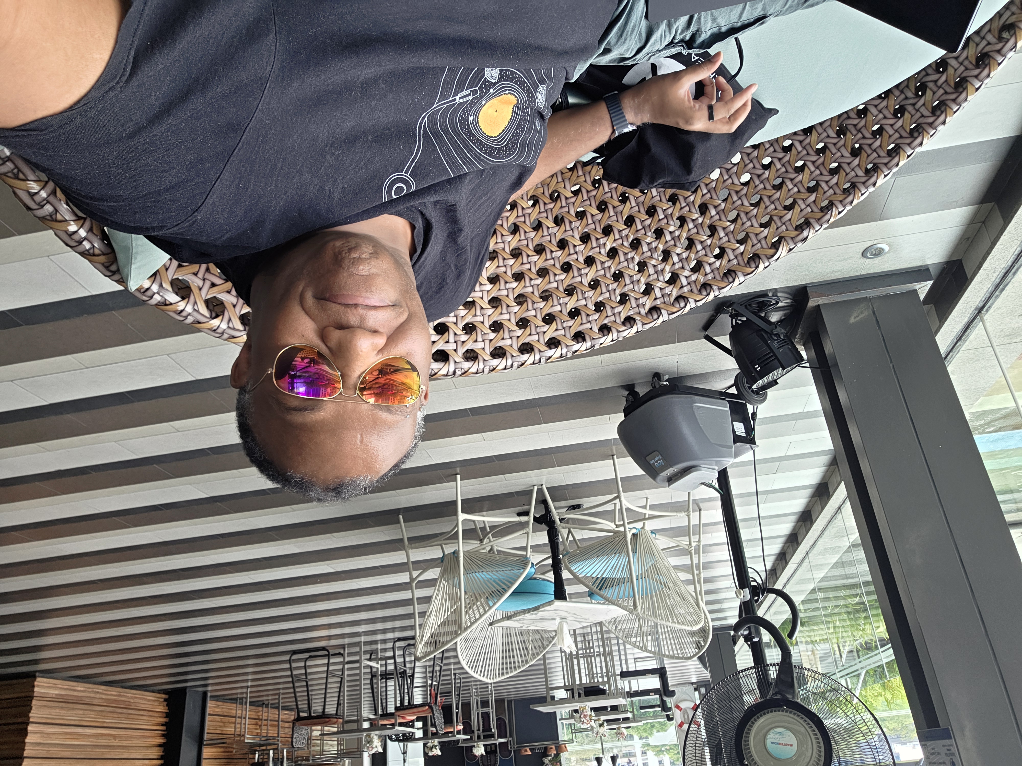 Rodney on hotel rooftop/lounge, sunglasses, relaxed