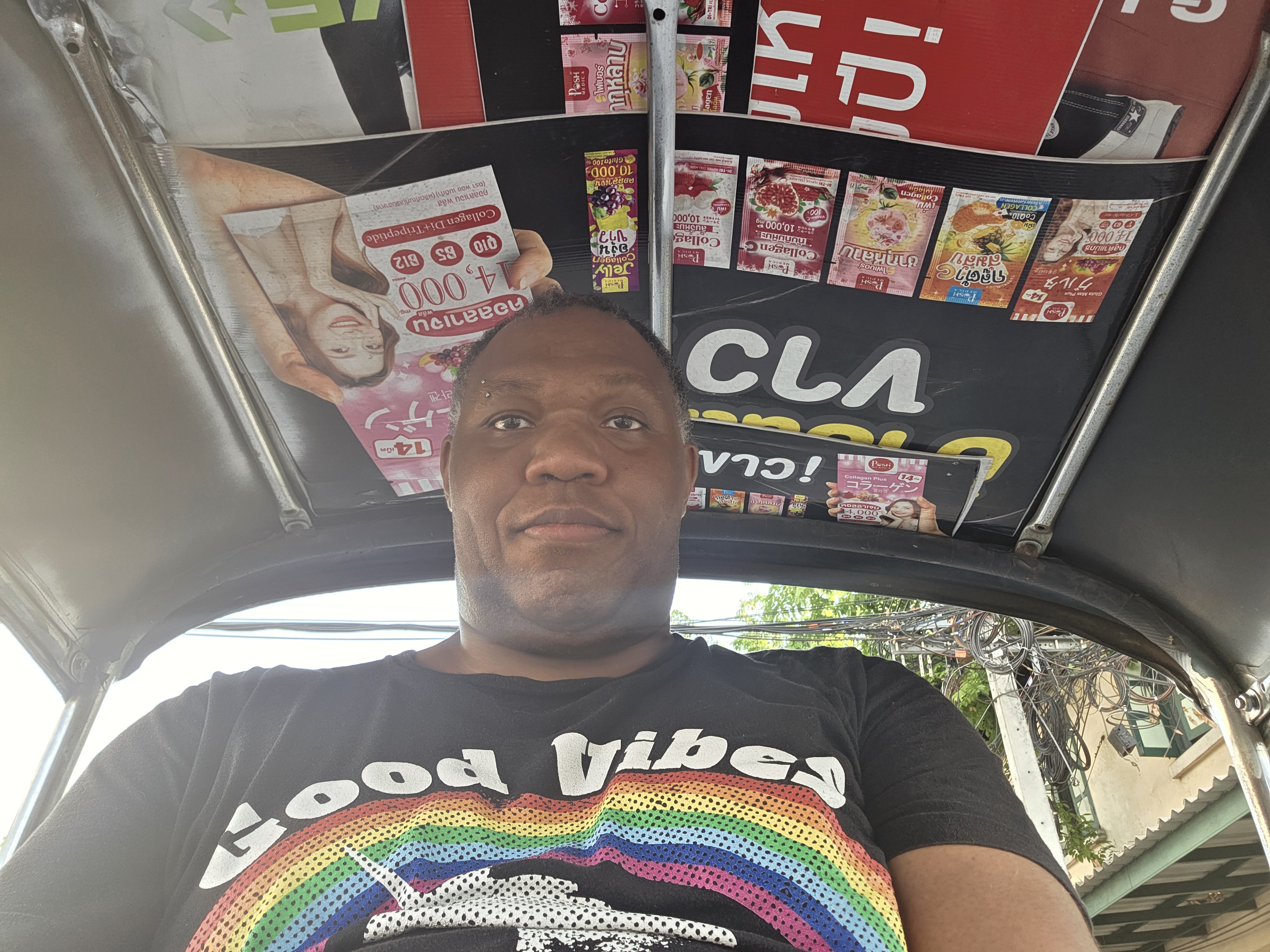 tuk-tuk selfie, ad-covered canopy, Good Vibes t-shirt