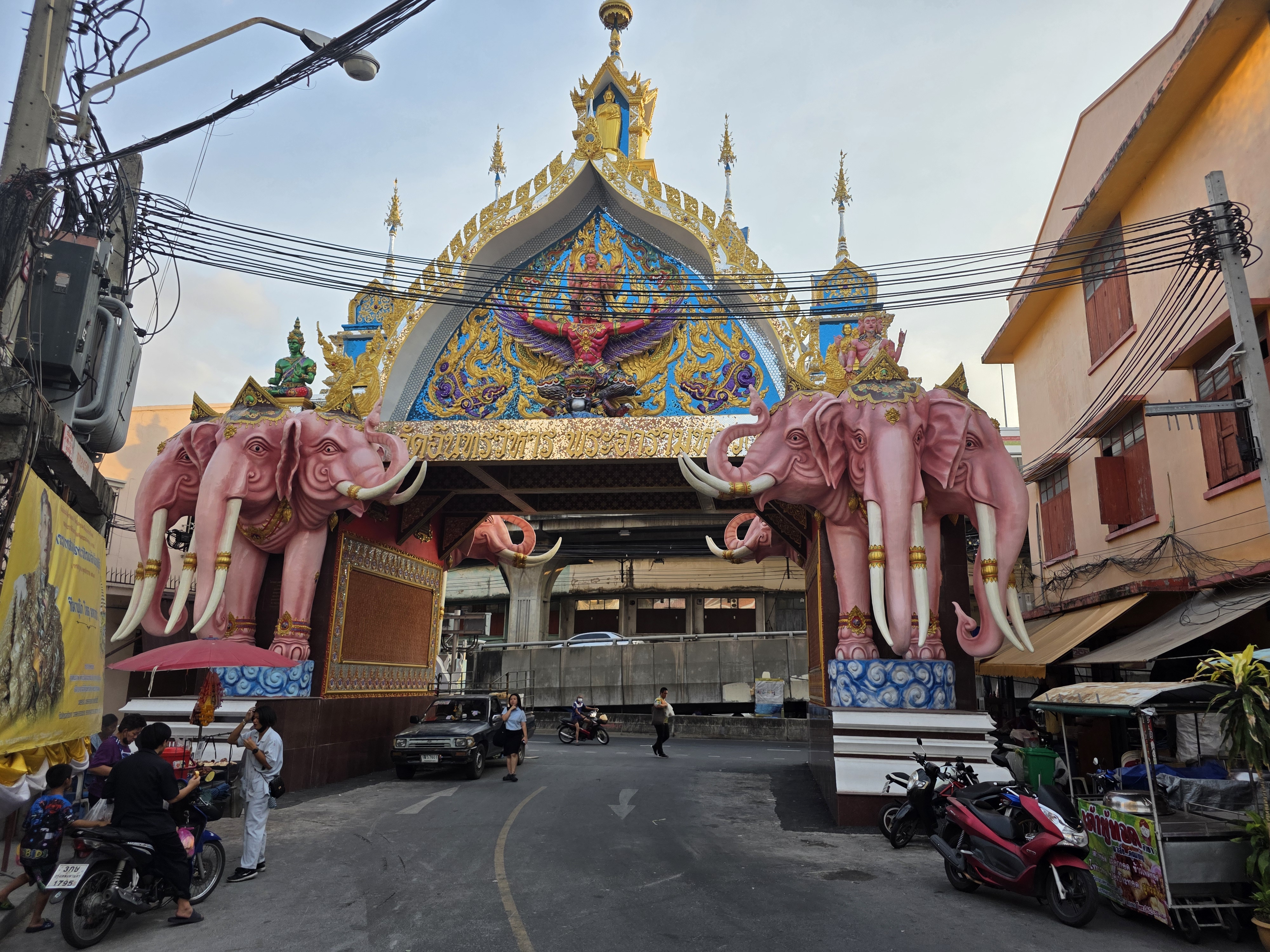 pink three-headed elephant gateway arch spanning a Bangkok street