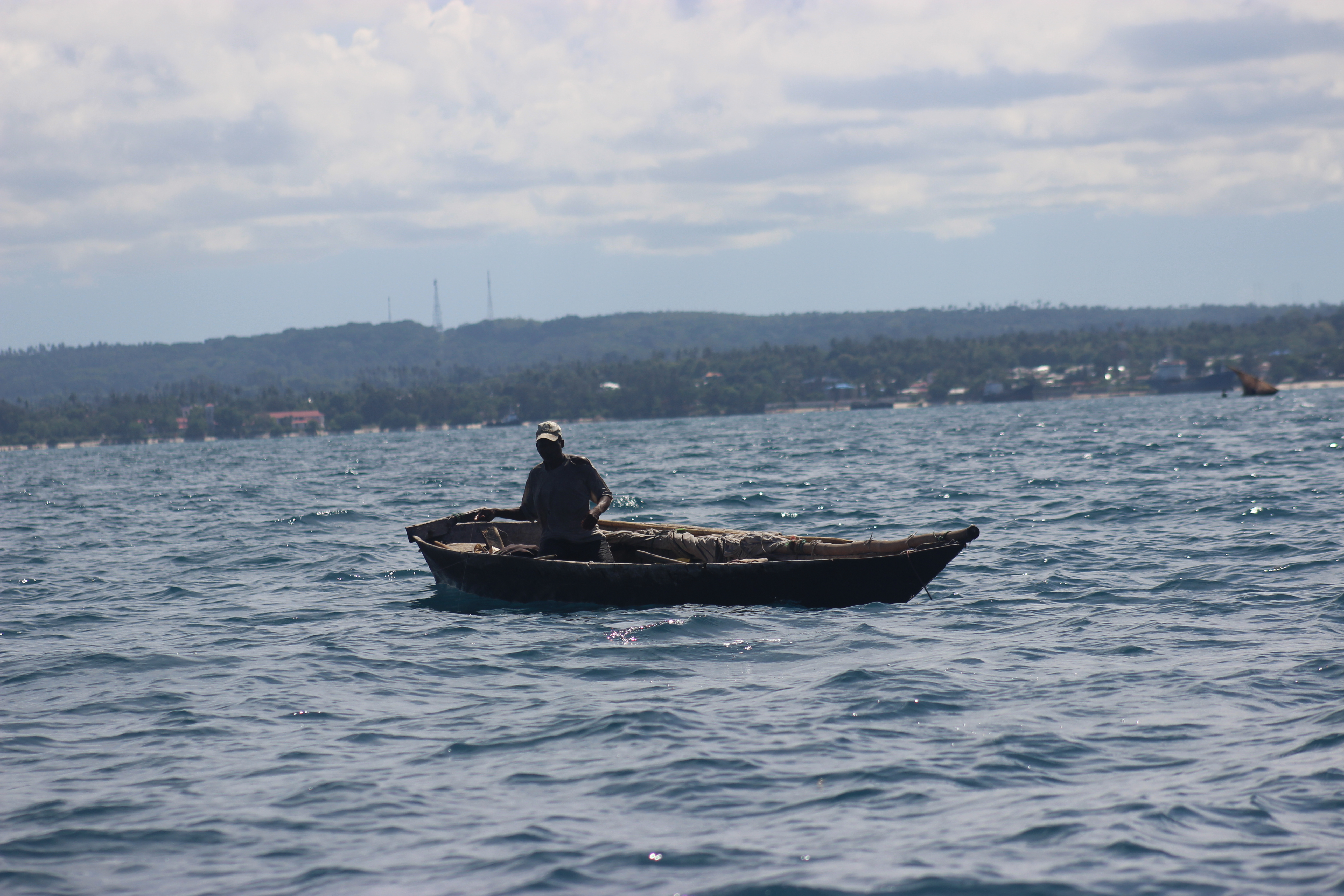Fisherman alone in a small wooden boat on the Indian Ocean, Zanzibar