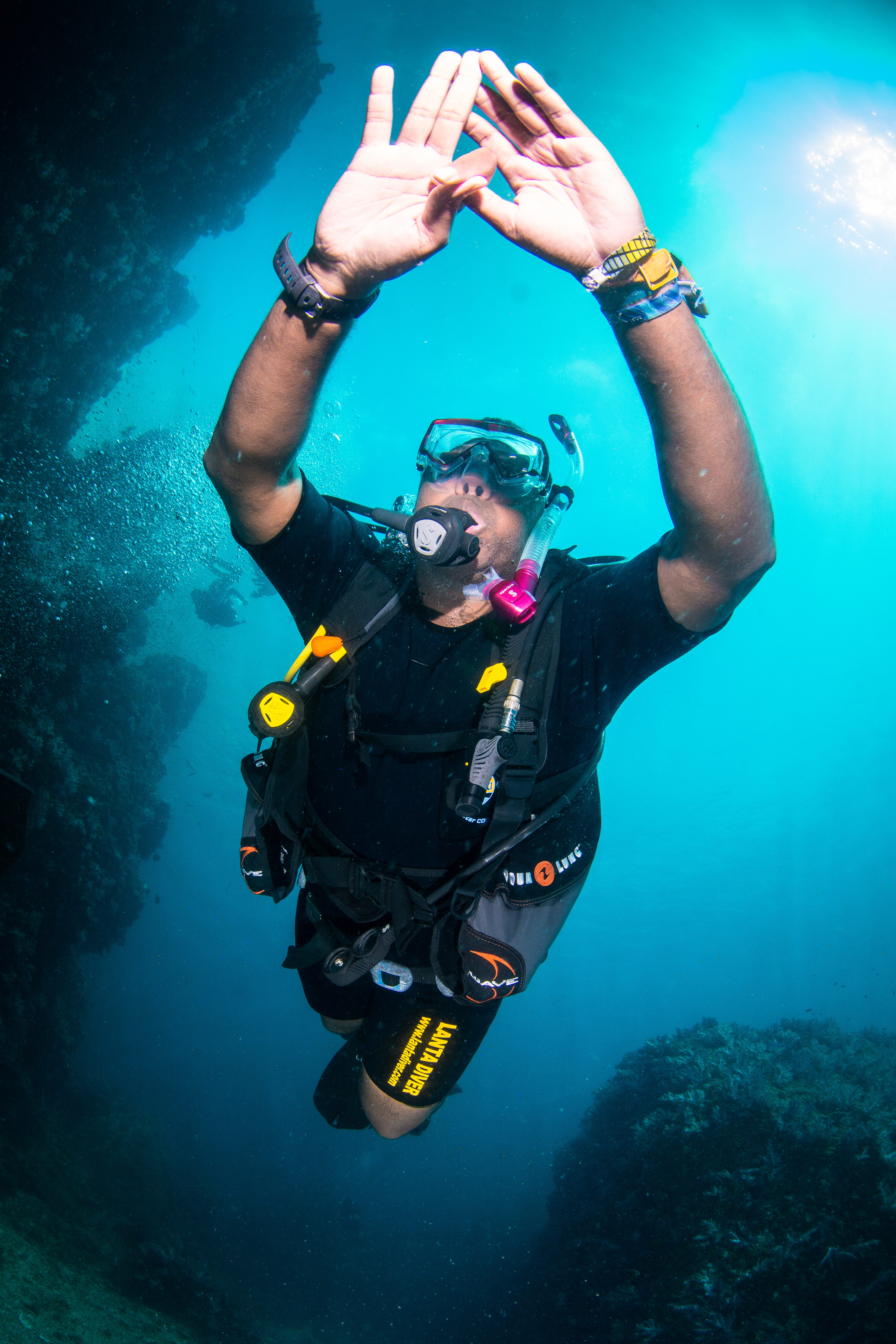 Rodney underwater, double OK sign, Lanta Diver shorts, teal water