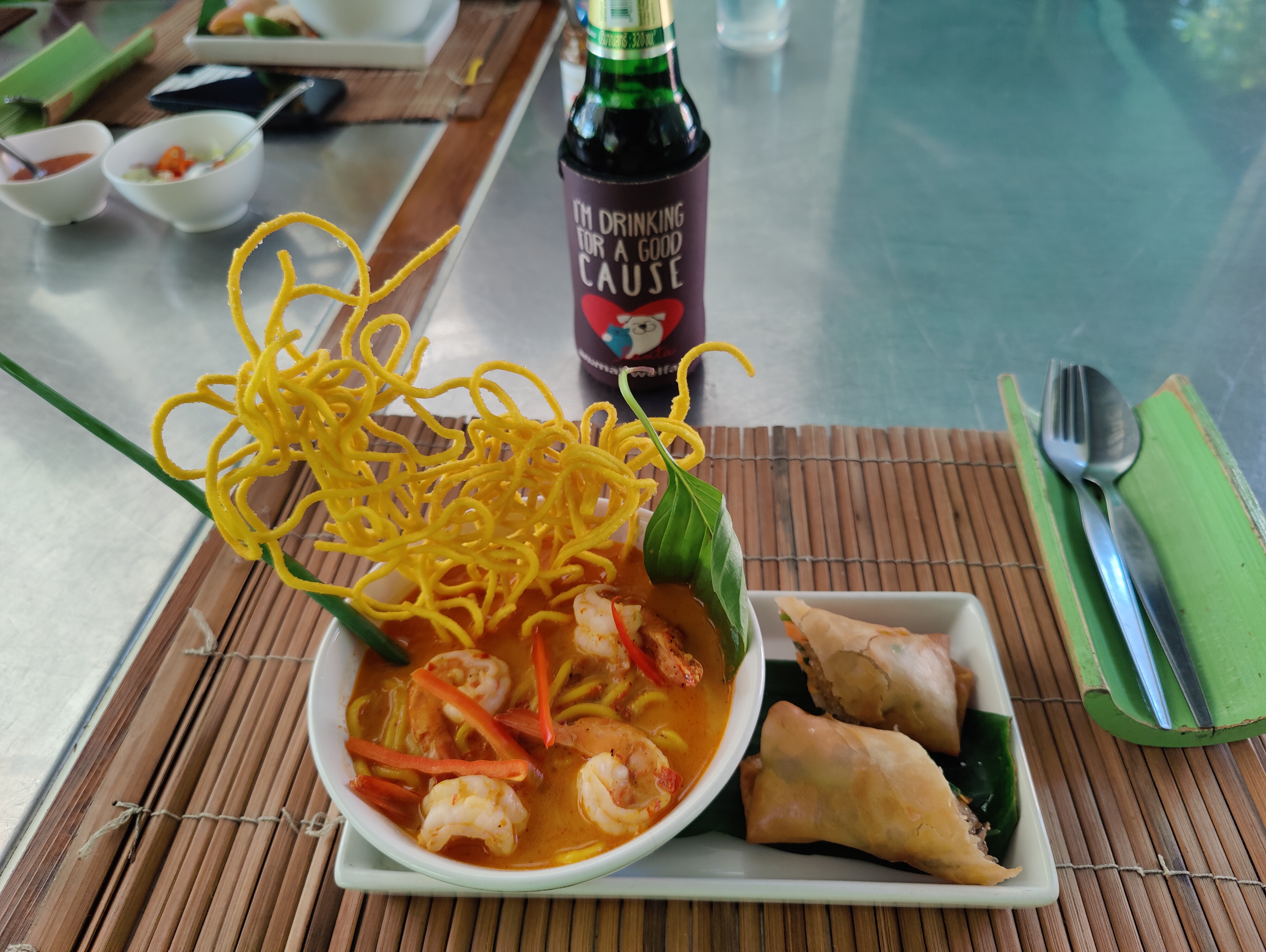 finished prawn curry with crispy noodles, spring rolls and charity beer