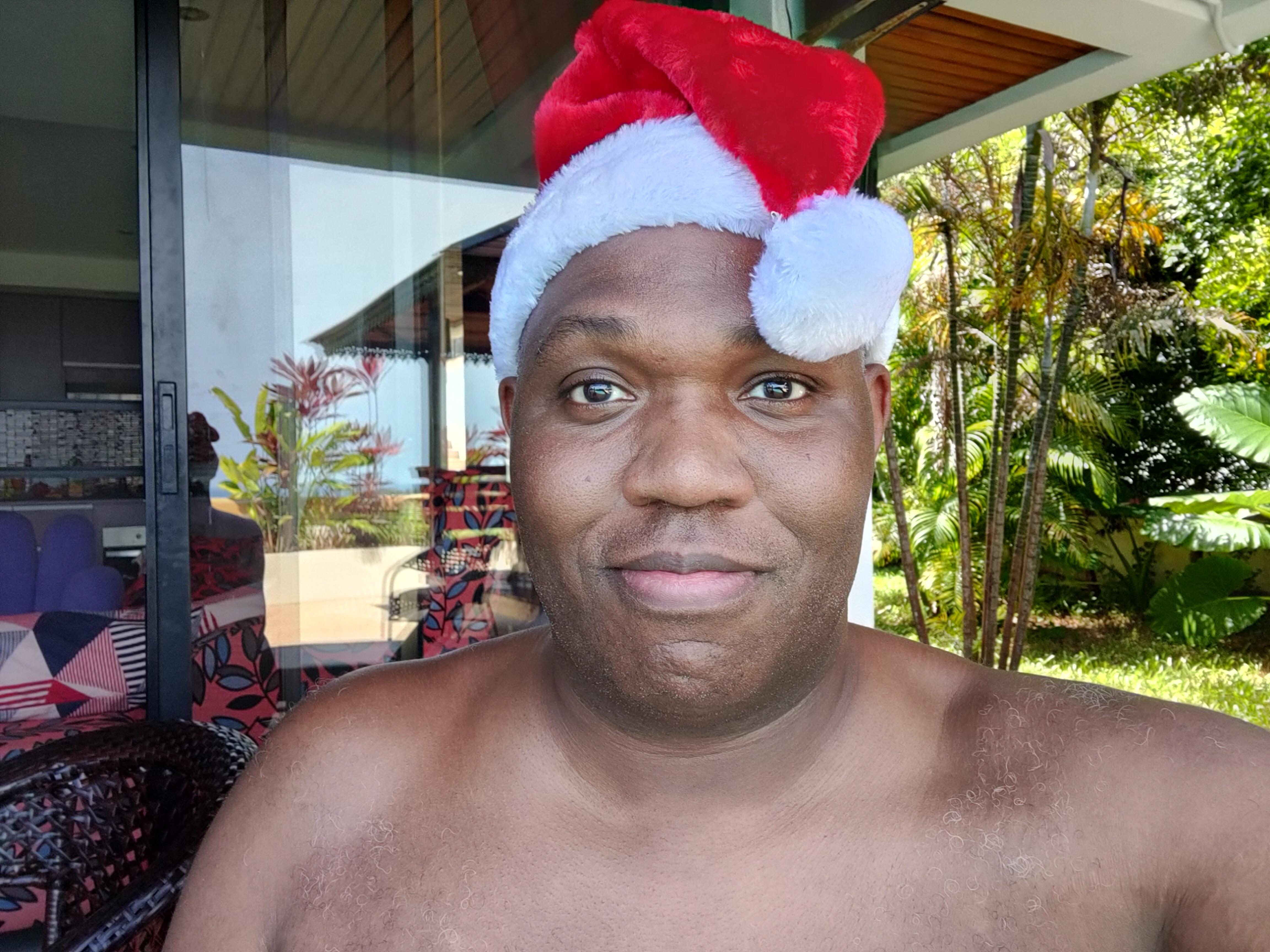 Rodney in Santa hat at the villa, tropical garden